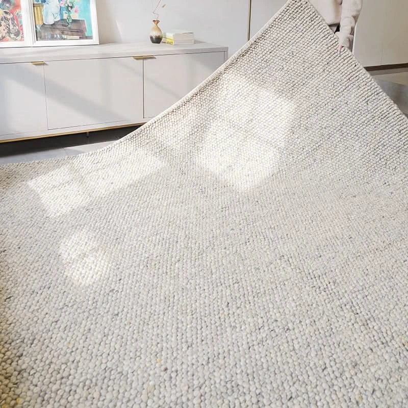 Luxurious wool rug, modern neutral design, showing soft texture in a bright living room setting.